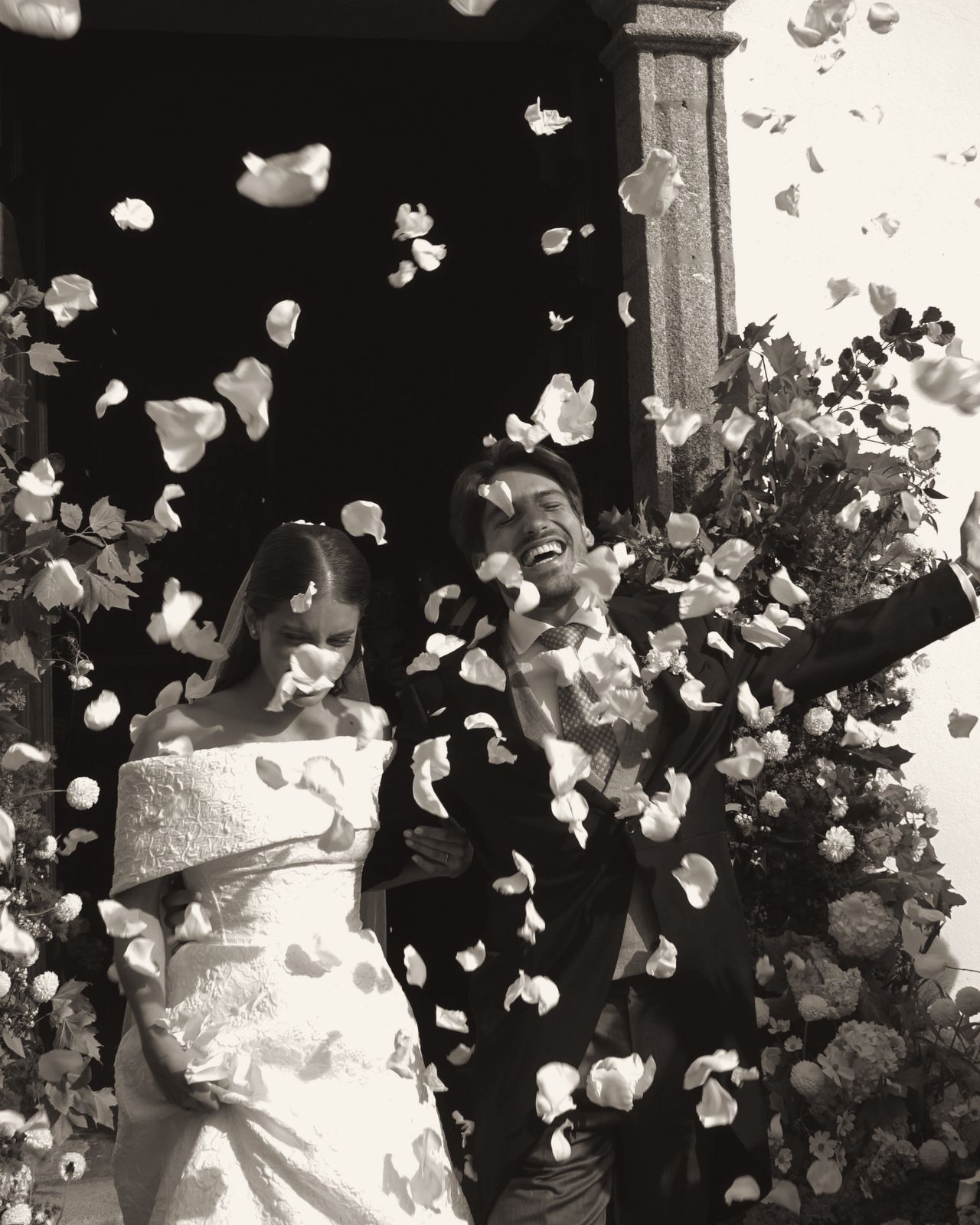 Couple leaving a church under a shower of petals