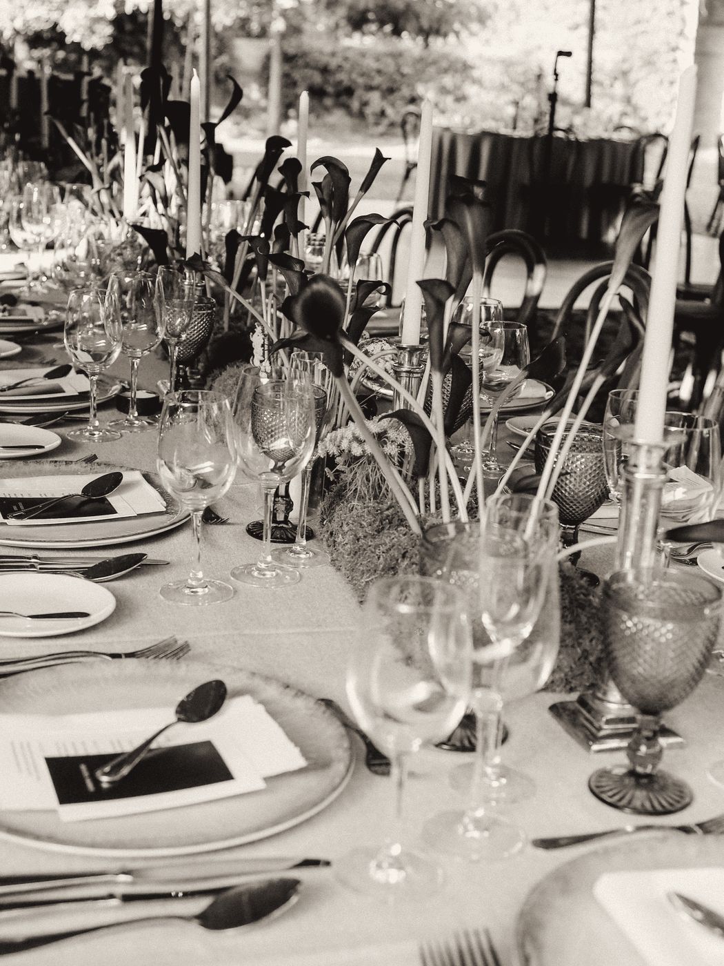 Long table with candles, moss and dark calla lilies
