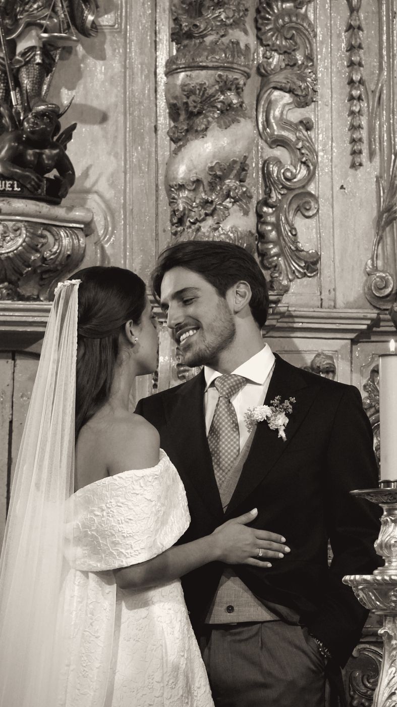 Bride and groom smiling at the altar of a gilded church
